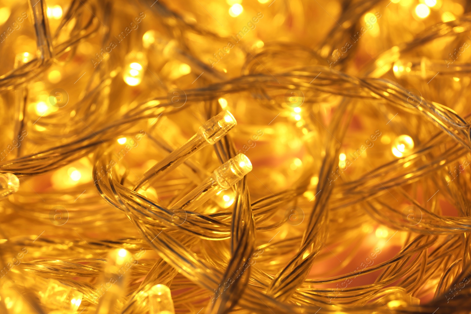 Photo of Golden glowing Christmas lights as background, closeup view