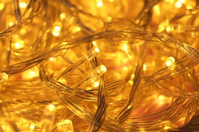 Golden glowing Christmas lights as background, closeup view