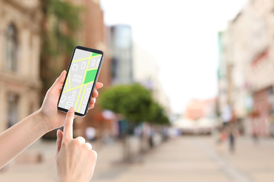 Image of Woman searching location with smartphone in city, closeup. Space for text 