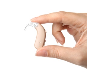 Photo of Woman holding hearing aid on white background, closeup