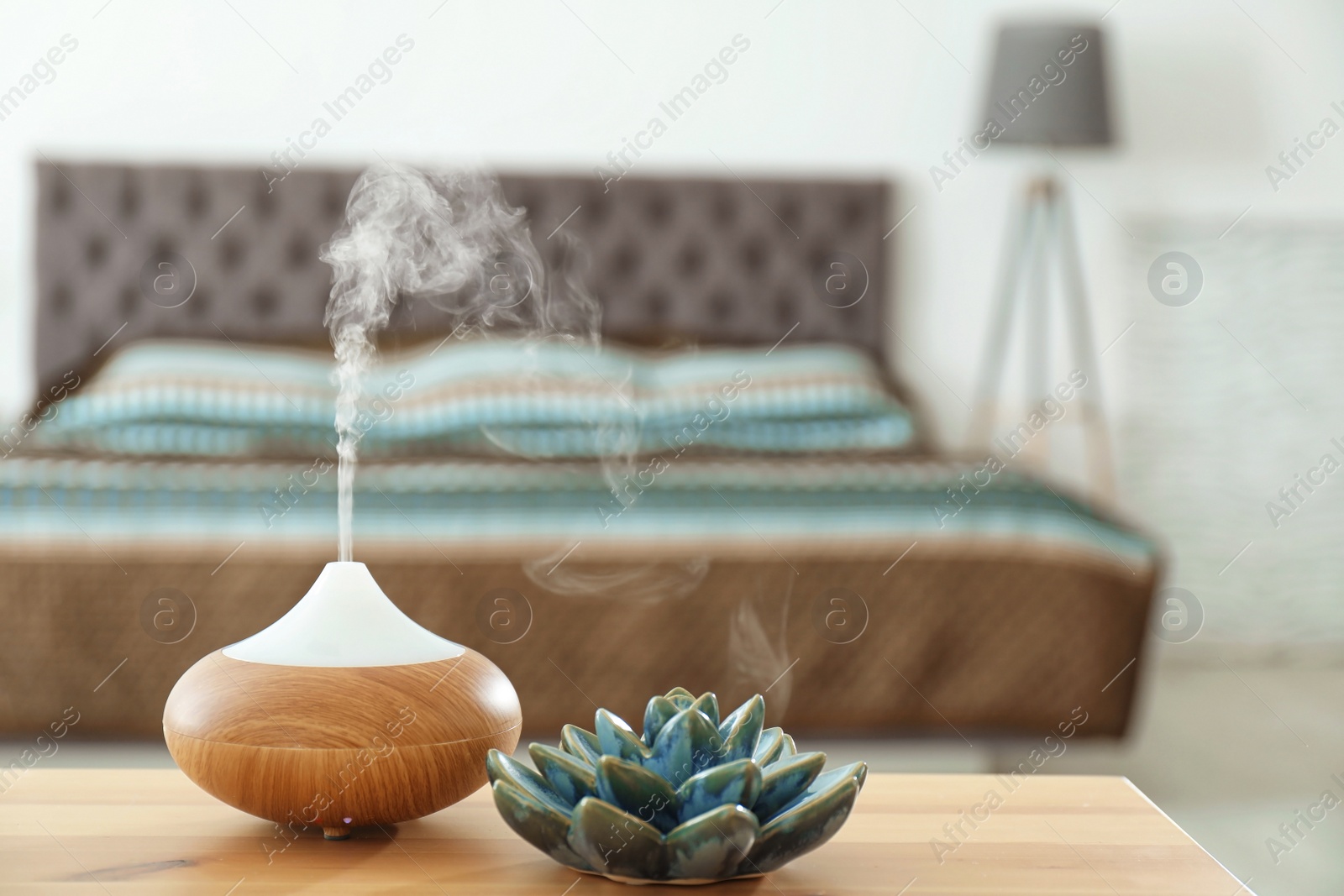 Photo of Aroma oil diffuser on table at home. Air freshener