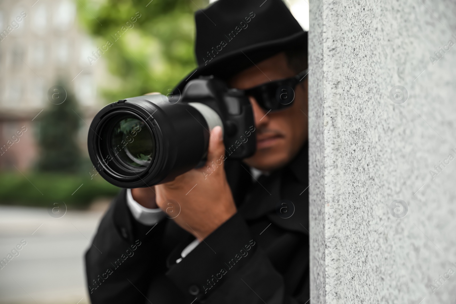 Photo of Private detective with modern camera spying outdoors, focus on lens