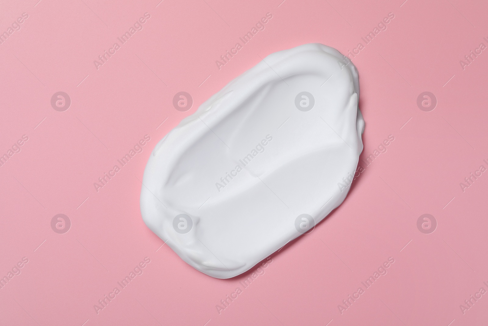 Photo of Sample of shaving foam on pink background, top view