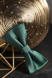 Photo of Stylish presentation of green bow tie on black table