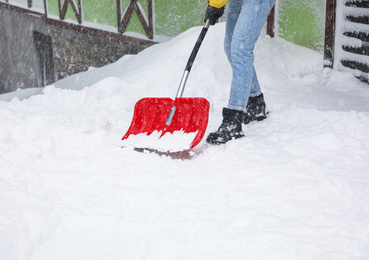 Photo of Man cleaning snow with shovel outdoors, closeup