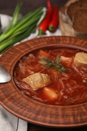 Photo of Bowl of delicious borscht on table, closeup.