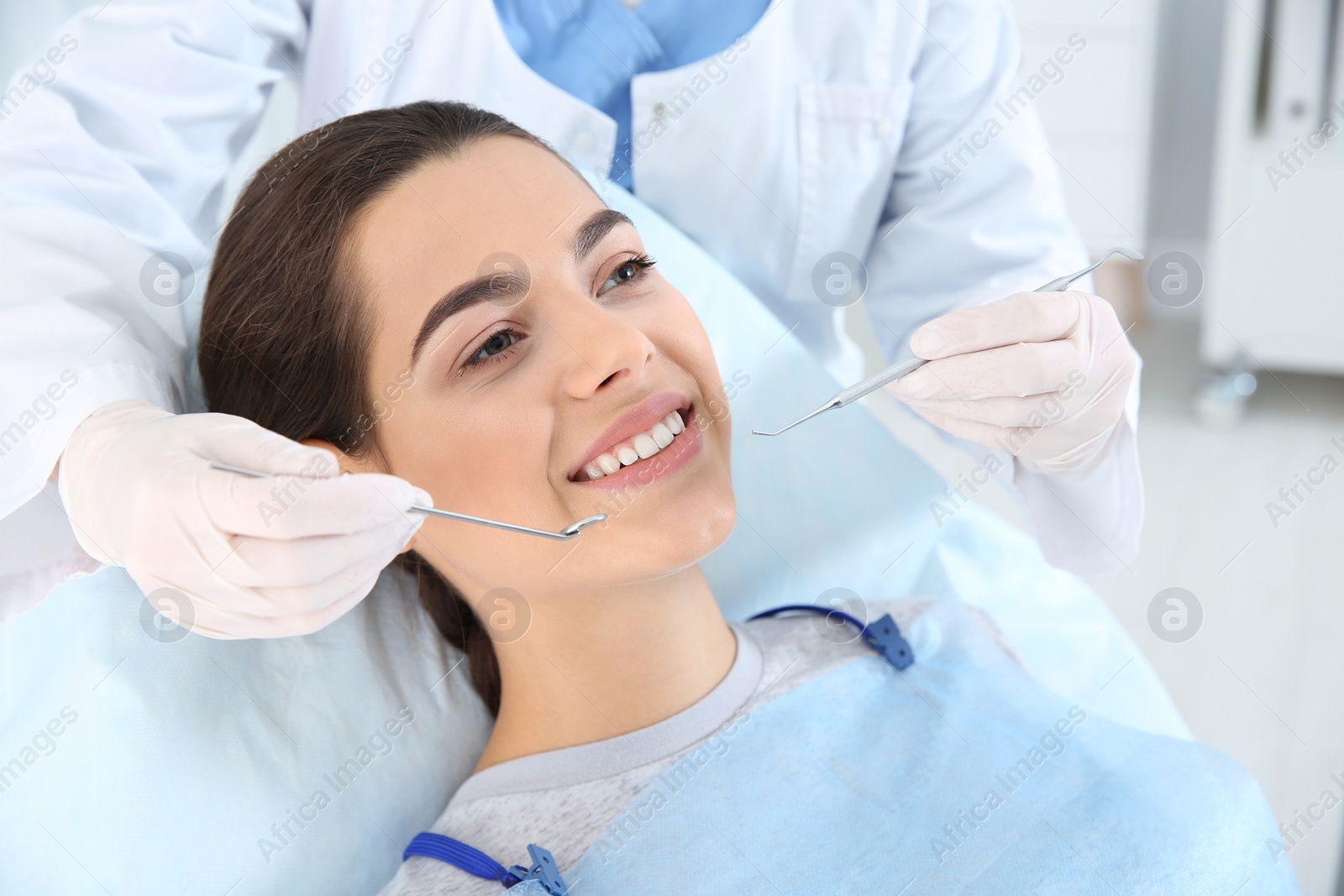 Photo of Dentist examining patient's teeth in modern clinic