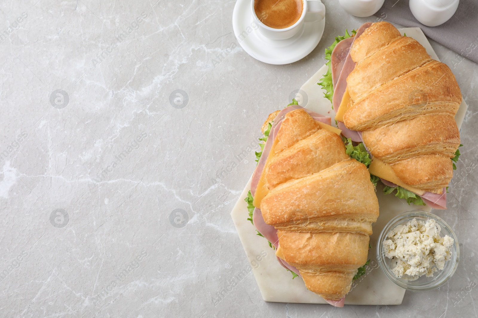 Photo of Tasty croissant sandwiches with ham served on grey table, flat lay. Space for text