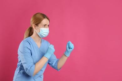 Photo of Doctor with protective mask in fighting pose on pink background, space for text. Strong immunity concept