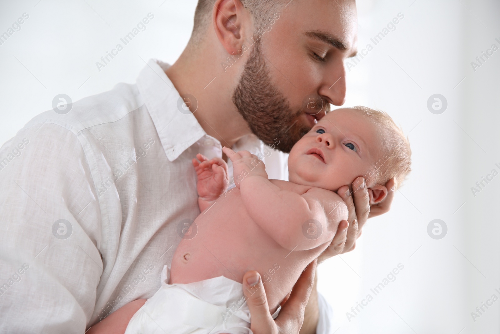 Photo of Father with his newborn son on light background, closeup