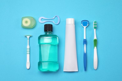 Photo of Flat lay composition with tongue cleaners and teeth care products on light blue background