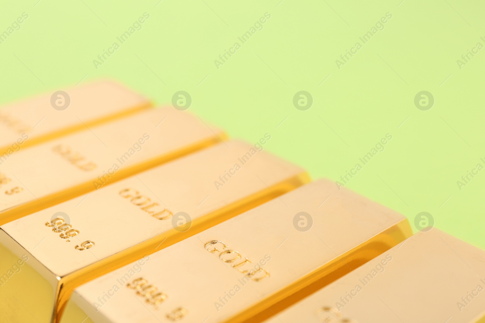 Photo of Gold bars on color background, closeup. Space for text
