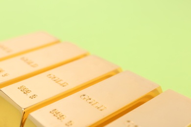 Photo of Gold bars on color background, closeup. Space for text