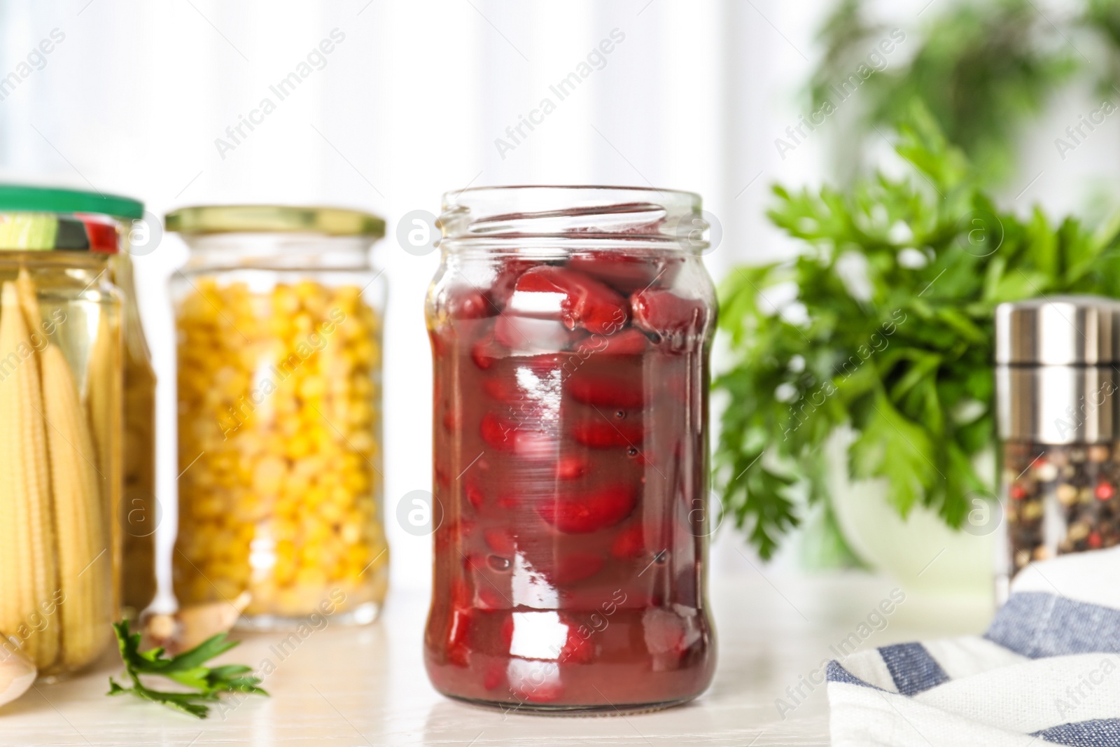 Photo of Glass jar of pickled beans on white table