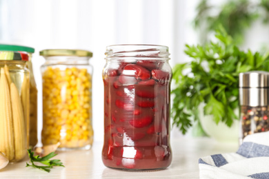 Glass jar of pickled beans on white table