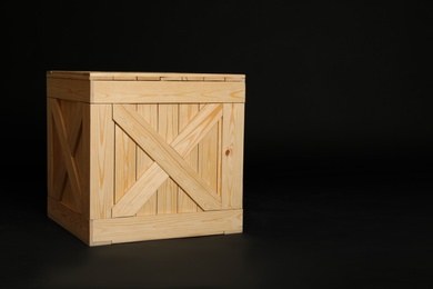 Photo of Wooden crate on black background. Space for text