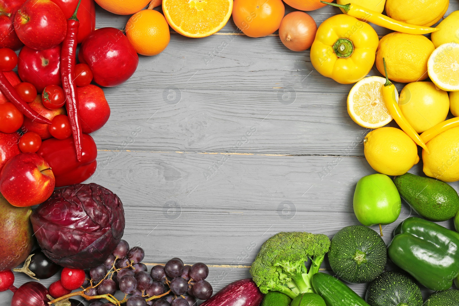 Photo of Rainbow frame made of fresh fruits and vegetables on wooden background