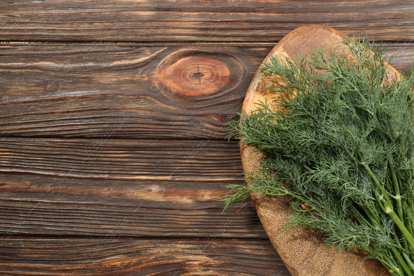 Photo of Bunch of fresh green dill on wooden table, top view. Space for text