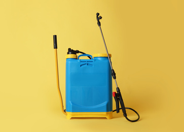 Photo of Manual insecticide sprayer on yellow background. Pest control