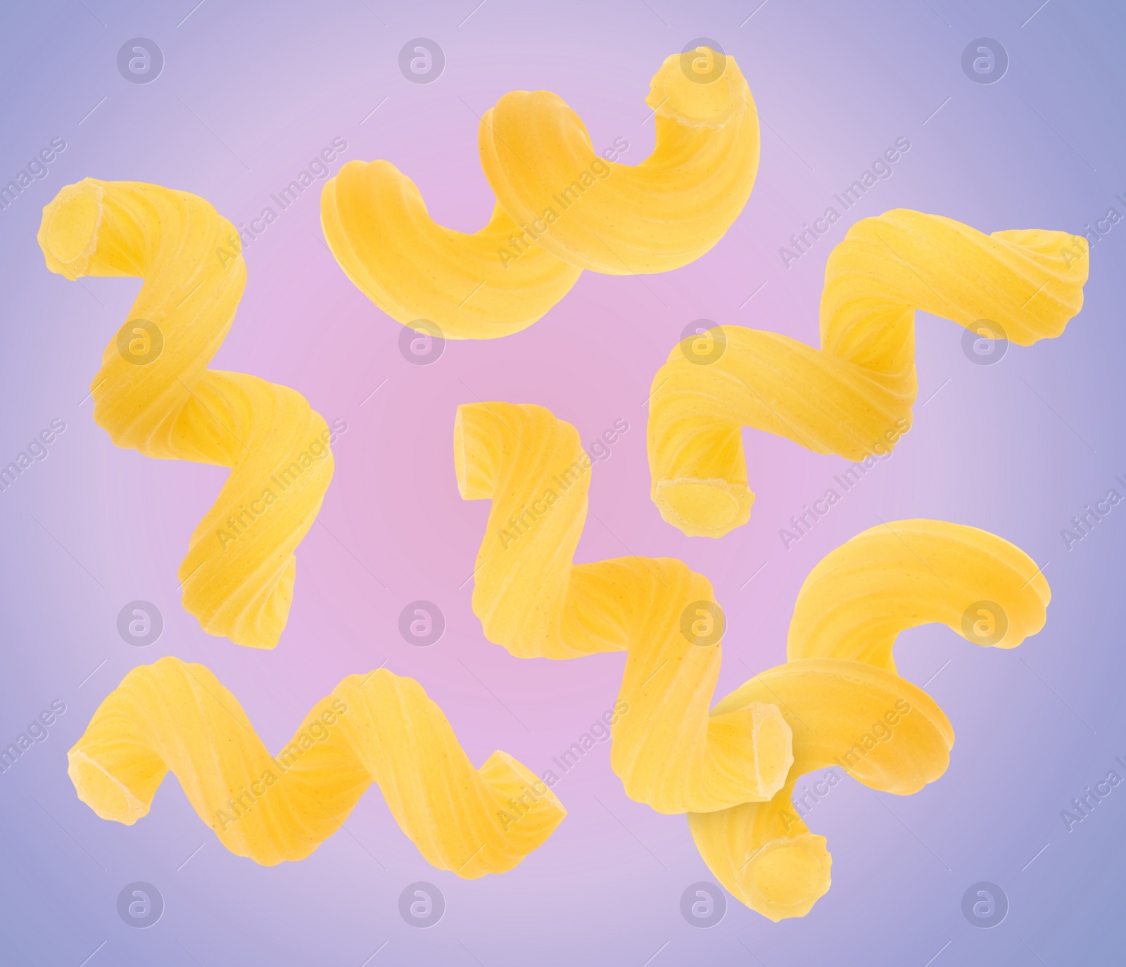 Image of Raw cavatappi pasta falling on color background
