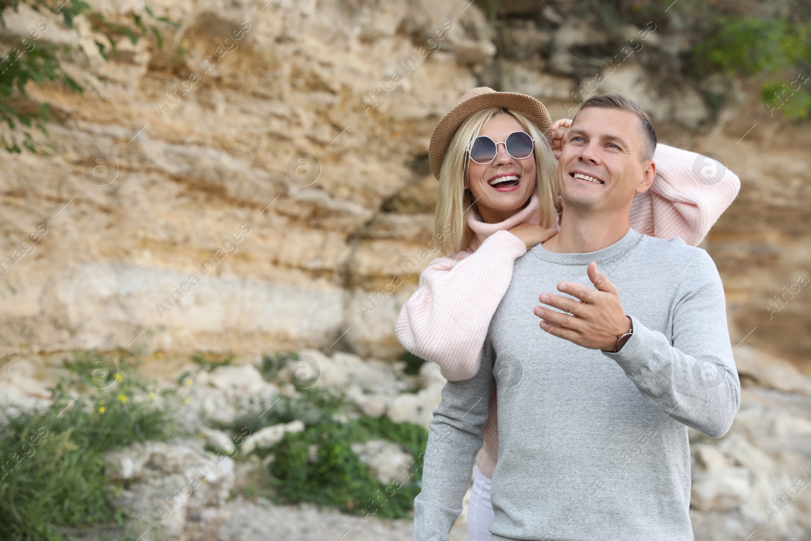 Photo of Happy couple in stylish sweaters near old cliff