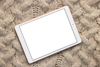 Photo of Modern tablet on beige fabric, top view. Space for text