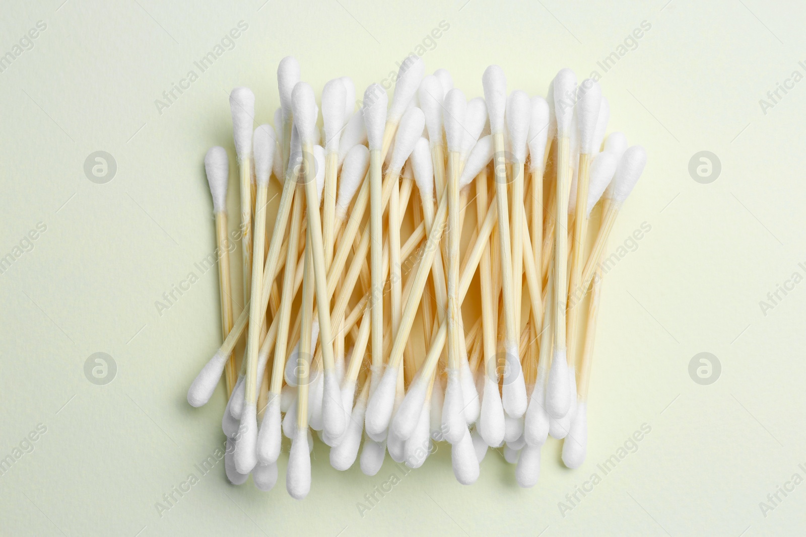 Photo of Heap of cotton buds on beige background, top view