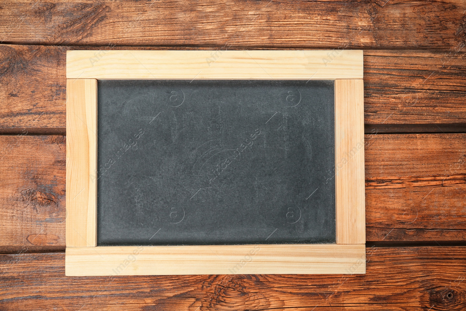 Photo of Empty clean chalkboard on wooden background