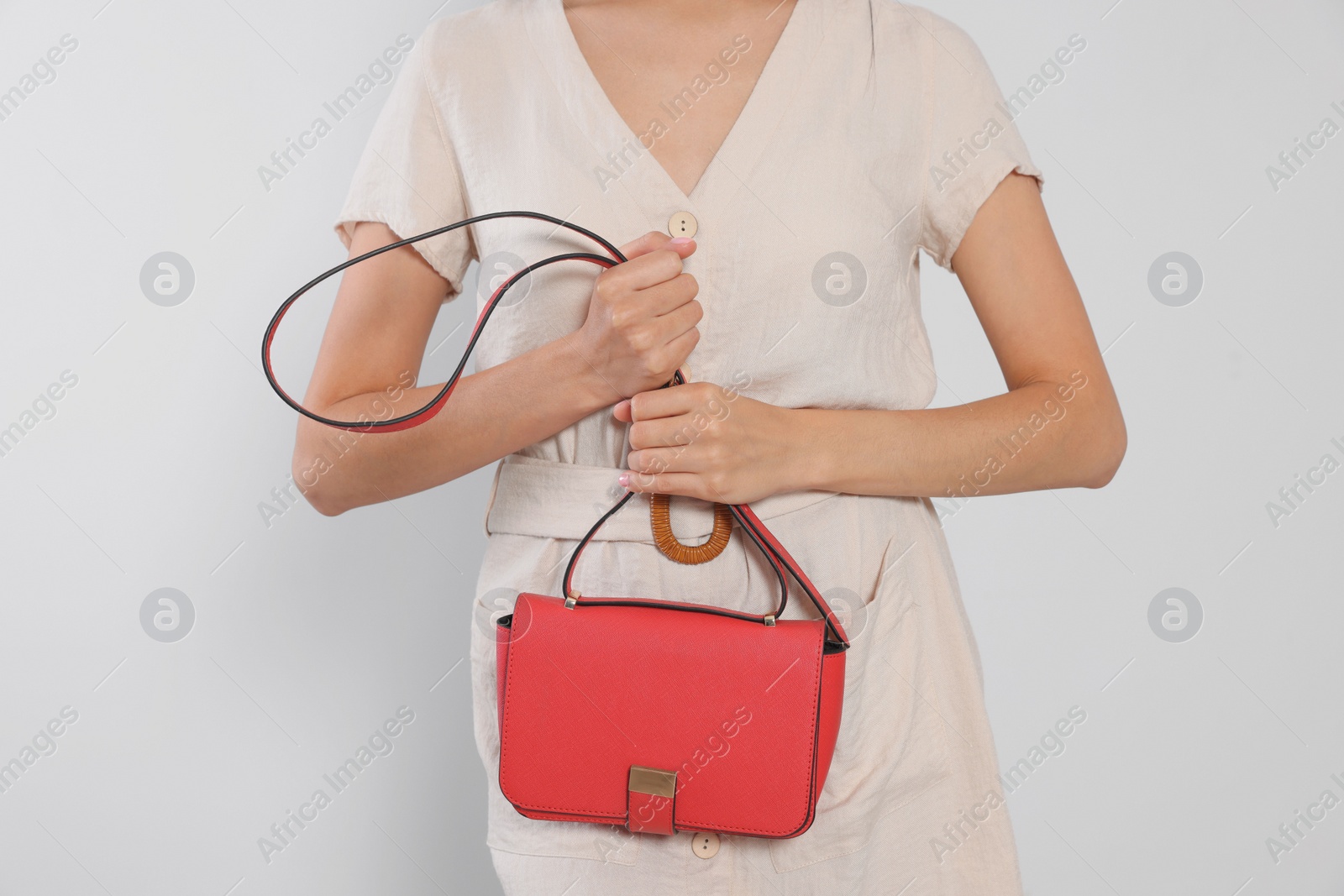 Photo of Woman with red stylish bag on light grey background, closeup