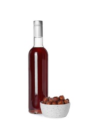 Photo of Delicious syrup and bowl of hazelnuts on white background
