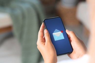 Woman received message on mobile phone indoors, closeup. Envelope illustration on device screen