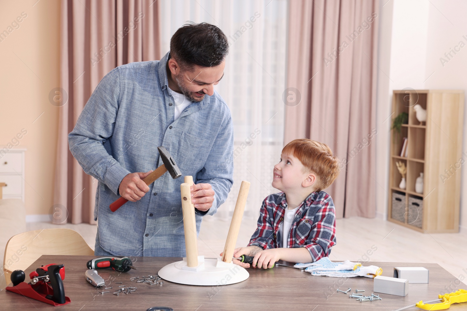 Photo of Father teaching son how to make stool at home. Repair work
