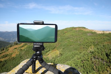 Taking video with modern phone on tripod in mountains