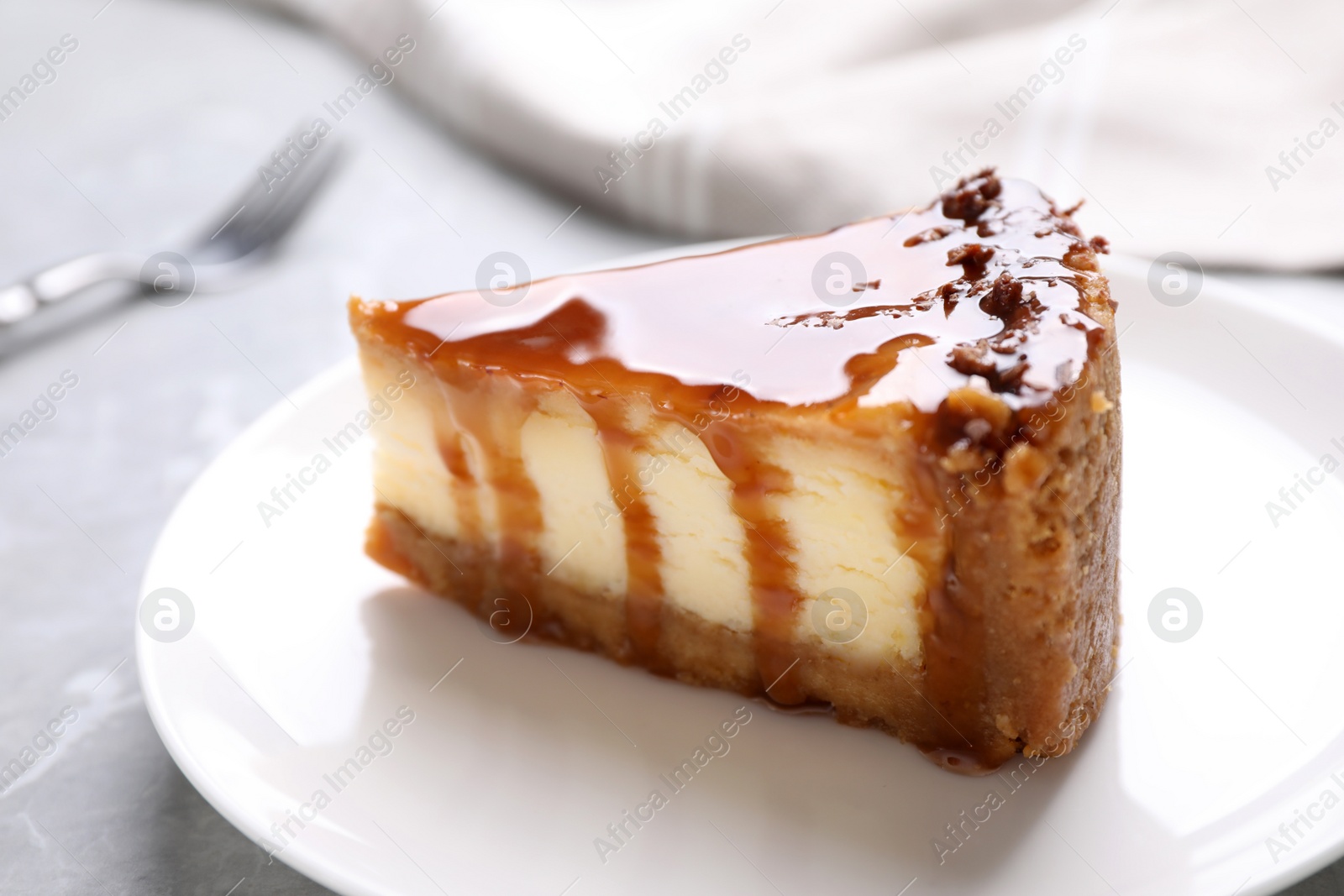 Photo of Piece of delicious cake with caramel on table, closeup