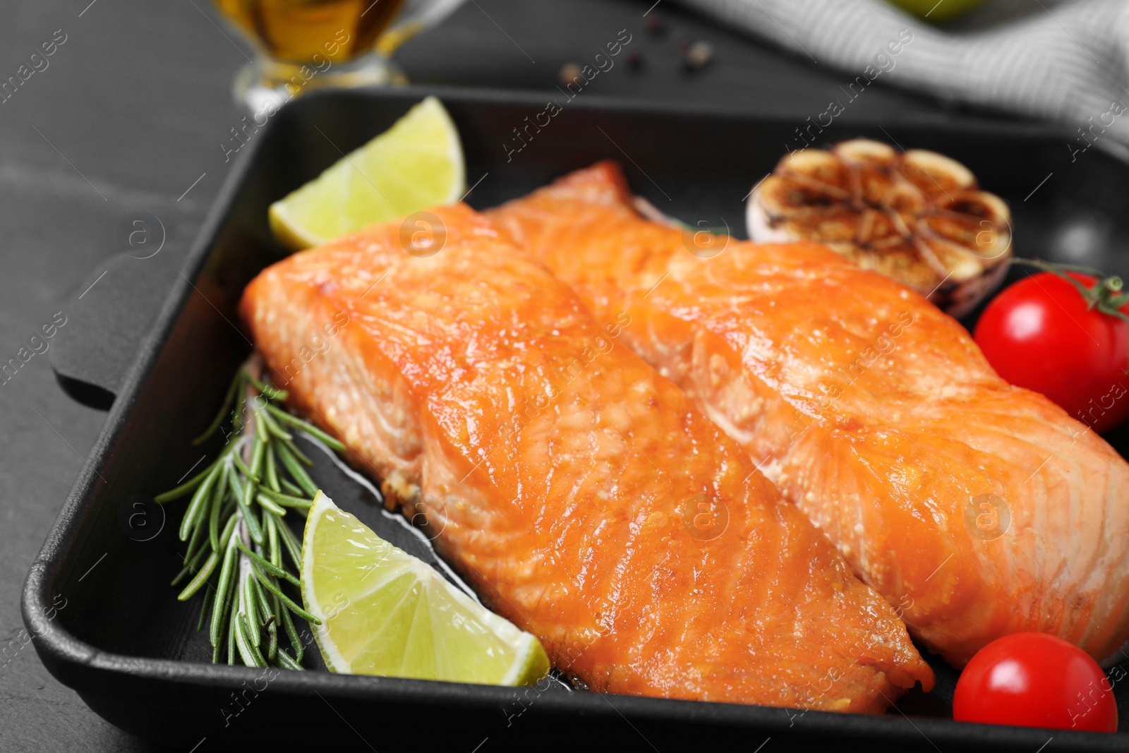 Photo of Delicious roasted fish served on black table, closeup