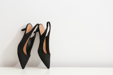 Photo of Pair of female shoes on table against white background