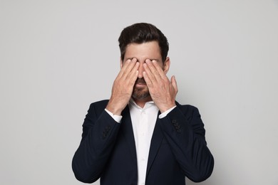 Photo of Man suffering from eyestrain on light grey background