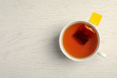 Cup of delicious tea on wooden background, top view