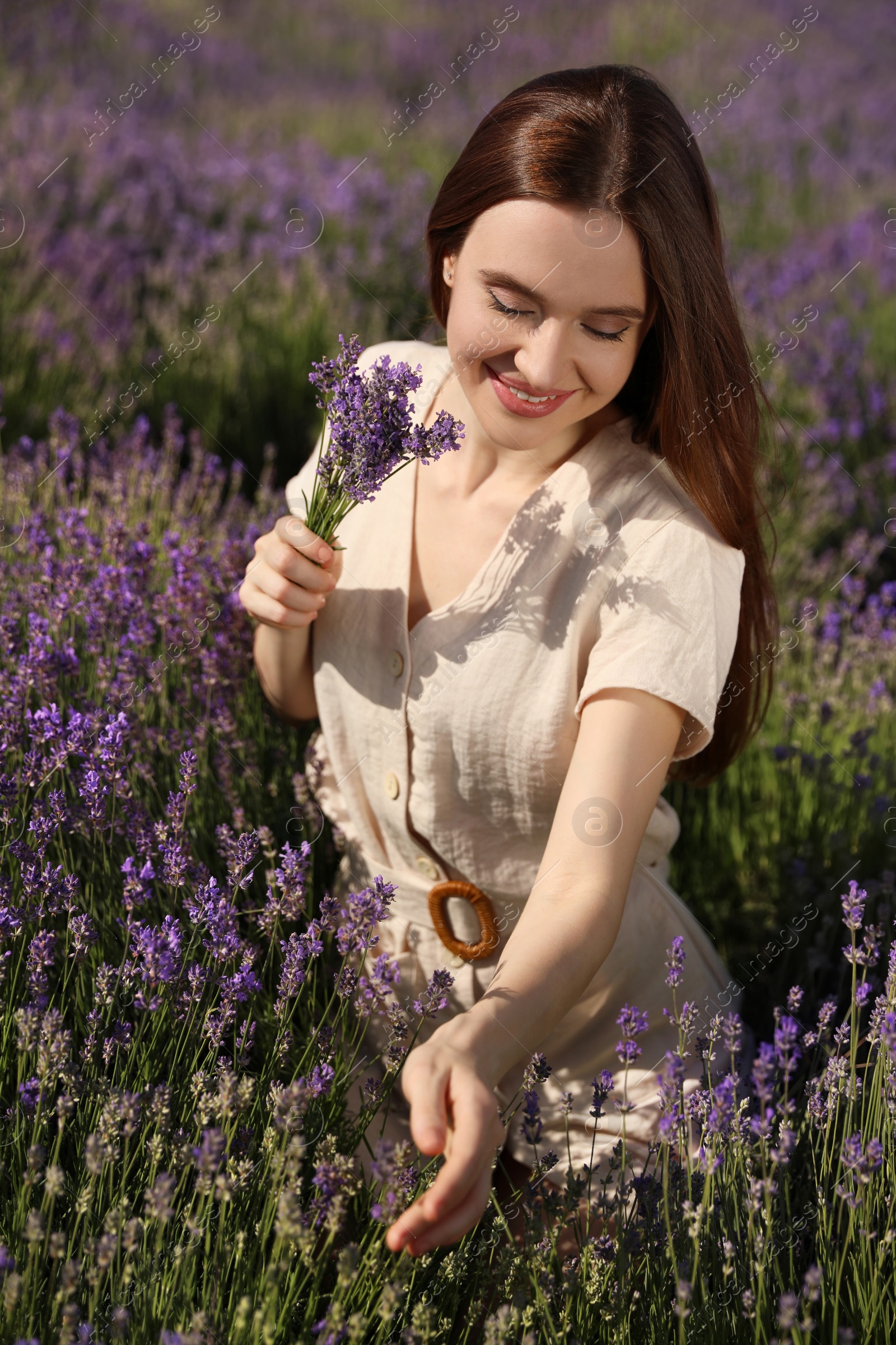 Photo of Young woman with lavender bouquet in field on summer day