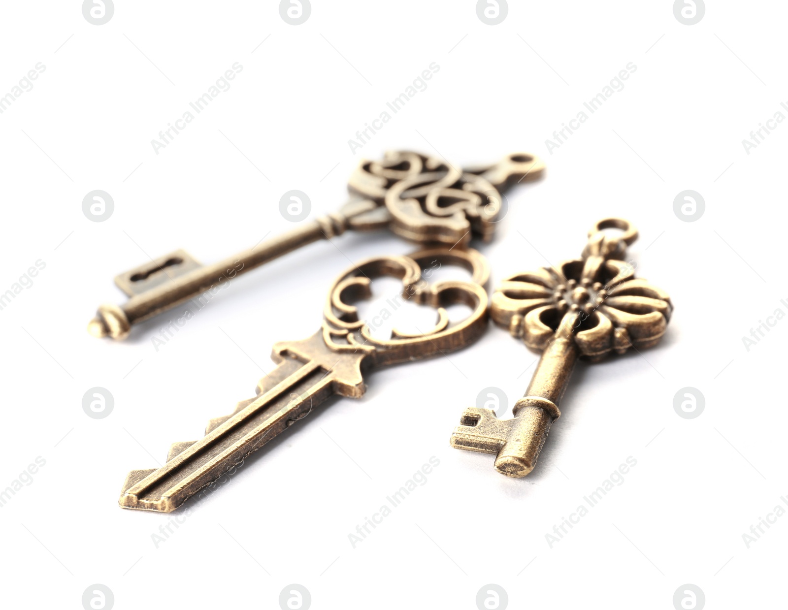 Photo of Bronze vintage ornate keys on white background