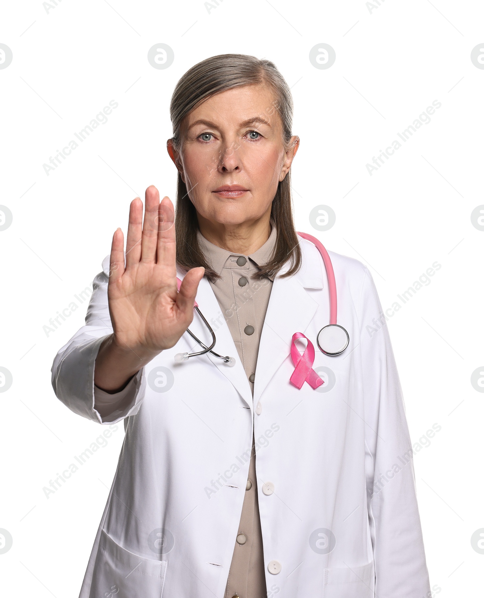 Photo of Mammologist with pink ribbon showing stop gesture on white background. Breast cancer awareness