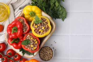 Photo of Flat lay composition with quinoa stuffed bell peppers on white tiled table. Space for text