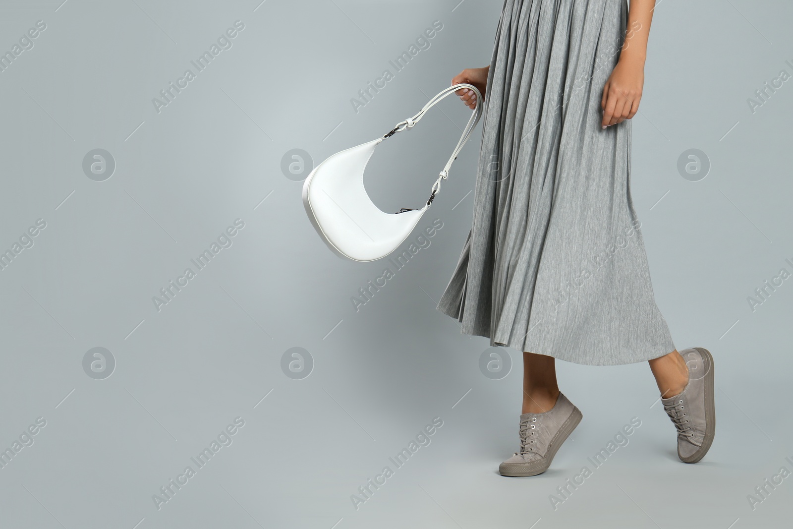 Photo of Woman with stylish bag on grey background, closeup. Space for text