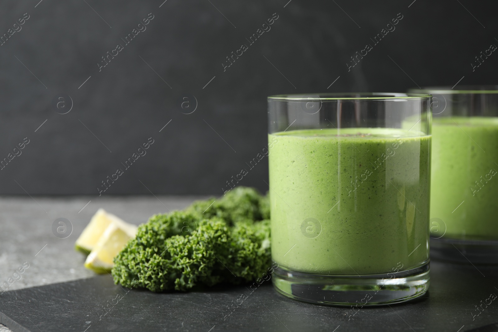 Photo of Tasty kale smoothie on black table, closeup