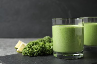 Photo of Tasty kale smoothie on black table, closeup