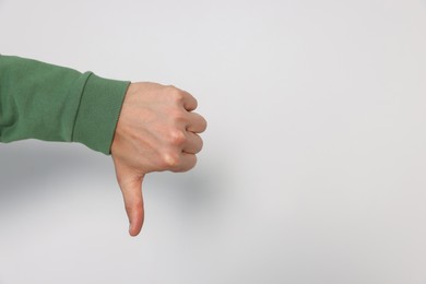 Photo of Man showing thumb down on white background, closeup. Space for text