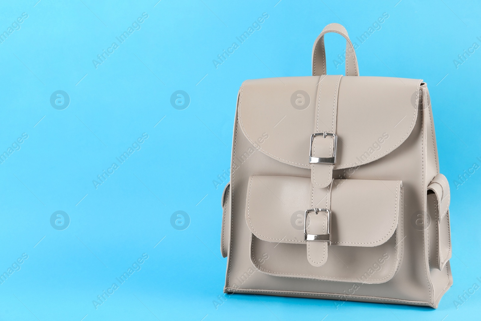 Photo of Stylish urban backpack on light blue background, space for text