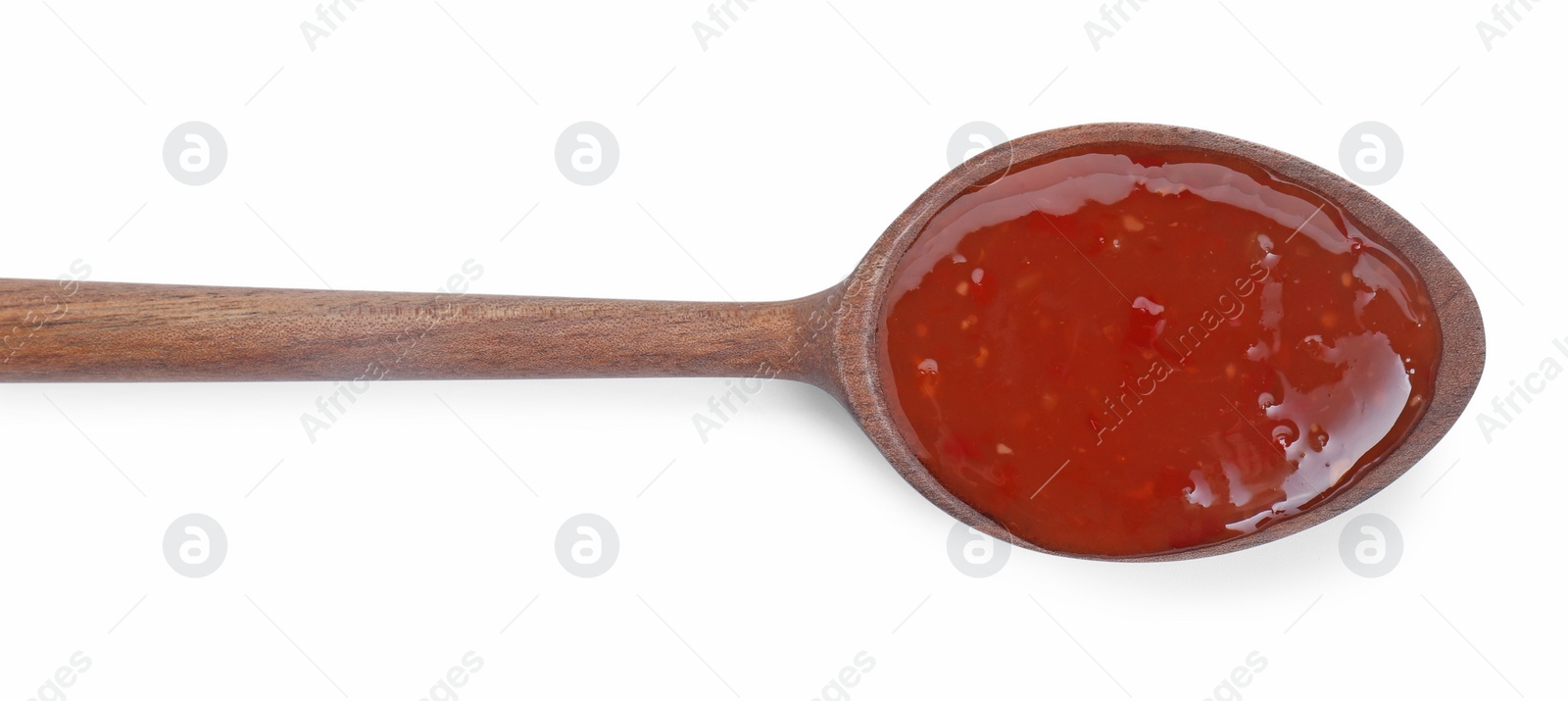 Photo of Spicy chili sauce in spoon isolated on white, top view