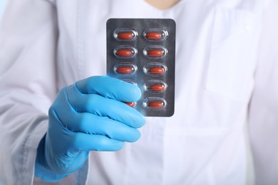 Photo of Doctor holding red pills, closeup. Anemia treatment