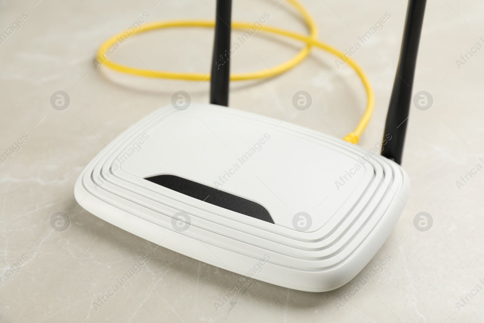 Photo of Modern Wi-Fi router on light grey marble background